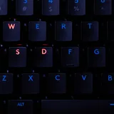 A backlit computer keyboard with red and blue keys