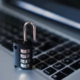 A combination padlock resting on a laptop keyboard