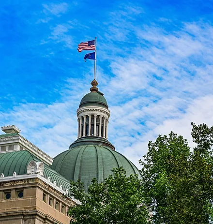 A green-domed government building with an American flag on top